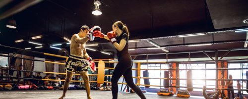 Modern gym facility in Bangkok, young athletes training for a Muay Thai class, women and men